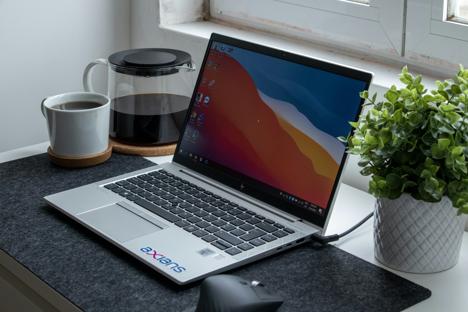 MacBook with code editor open on a clean black desk beside a white ceramic mug